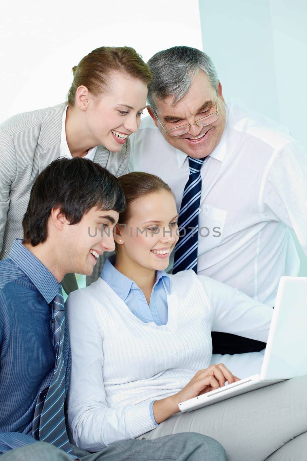 Portrait of successful partners looking at laptop screen in office