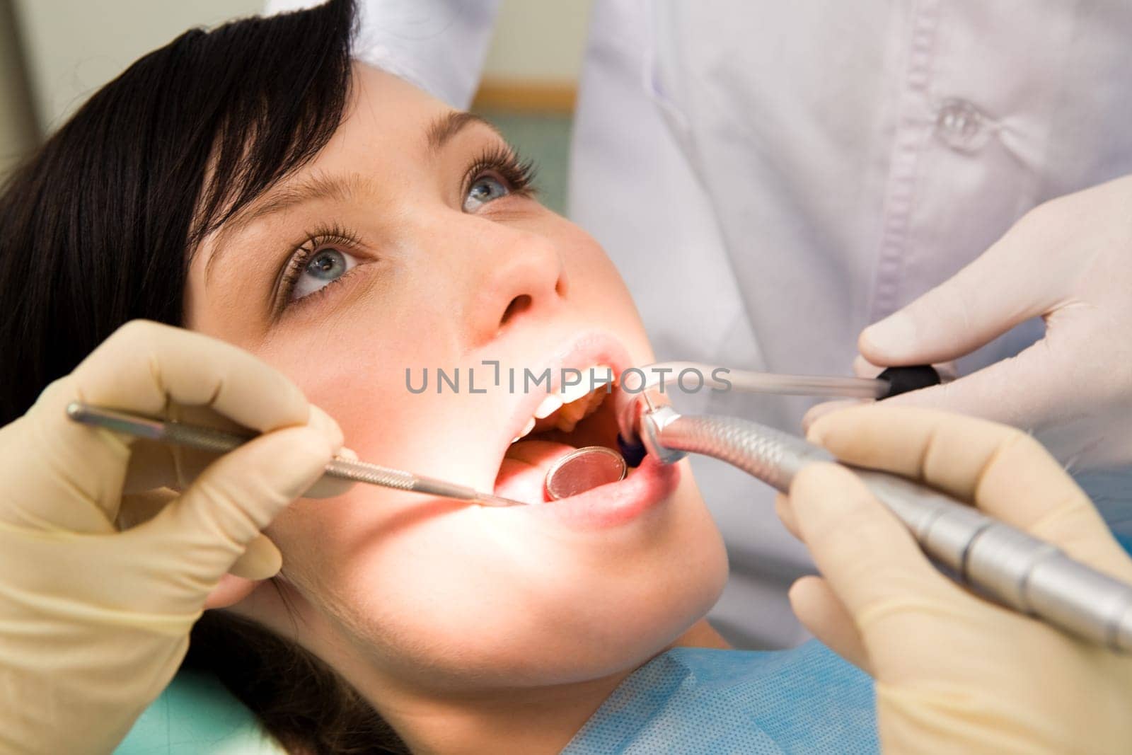 Close-up of beautiful female with open mouth having her teeth healed
