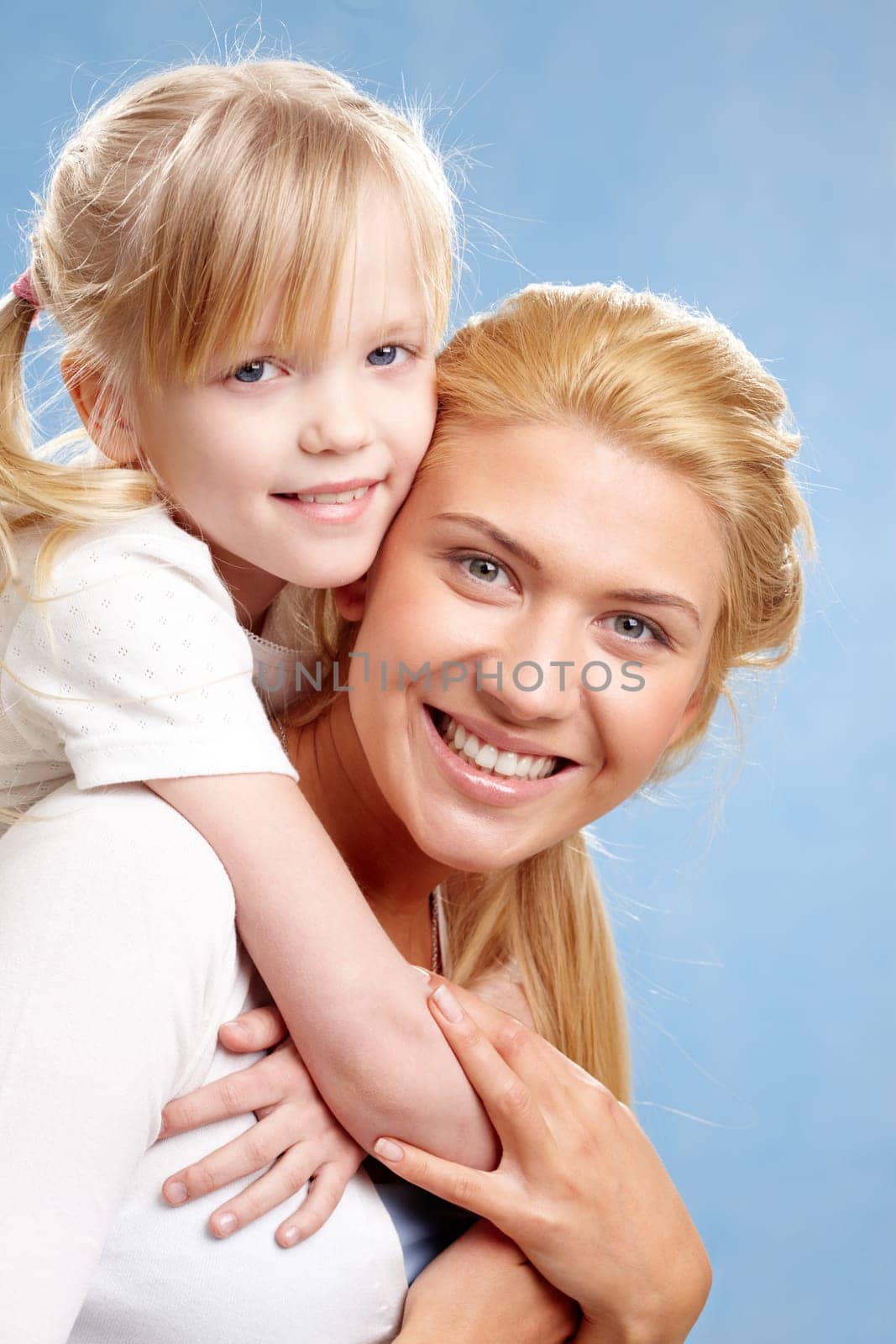 Portrait of young happy woman holding daughter on her back