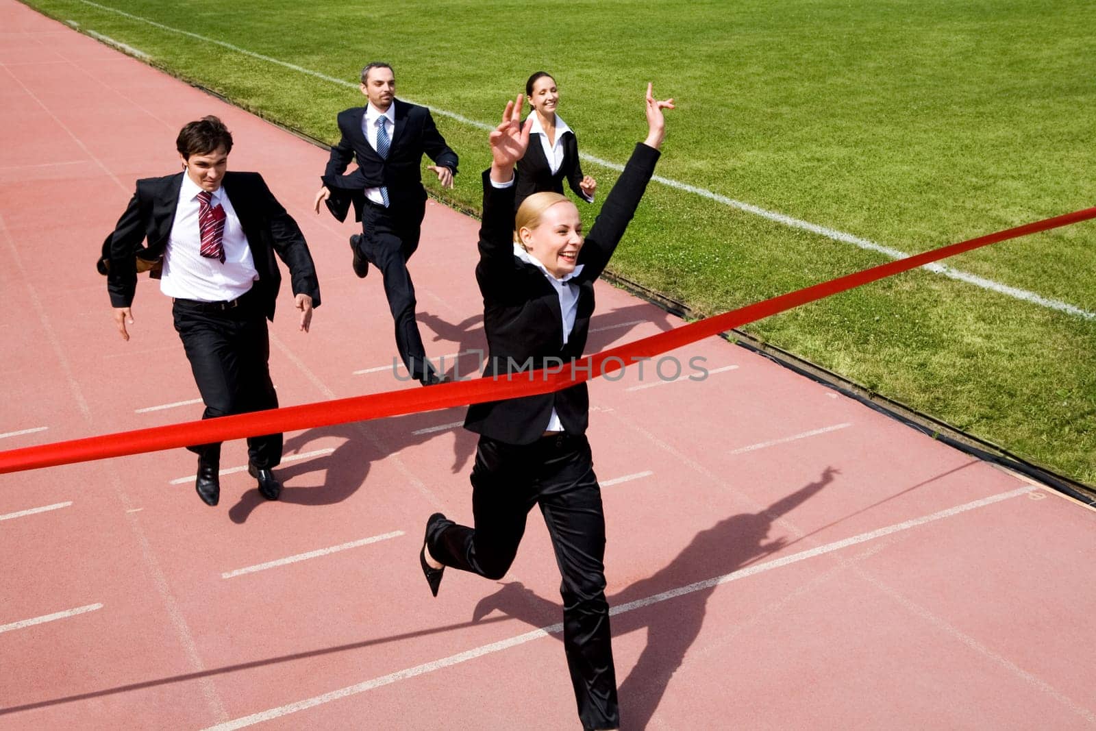 Photo of happy businesswoman crossing finish line during race
