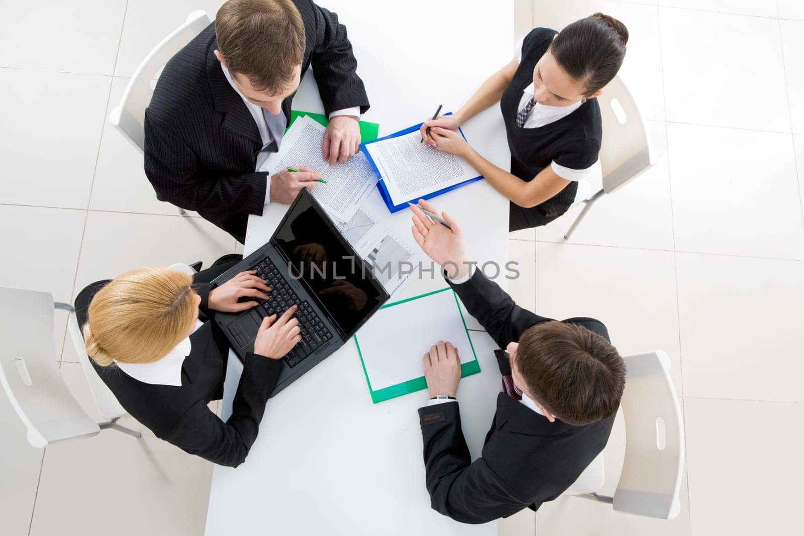 Above view of friendly workteam discussing business plan at meeting