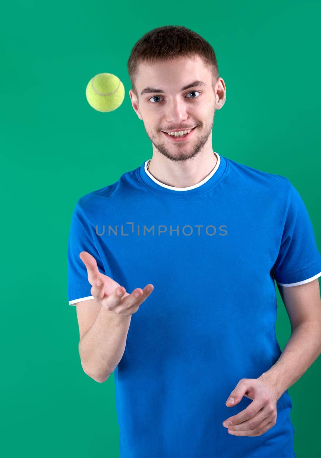 Portrait of young man playing with tennis ball