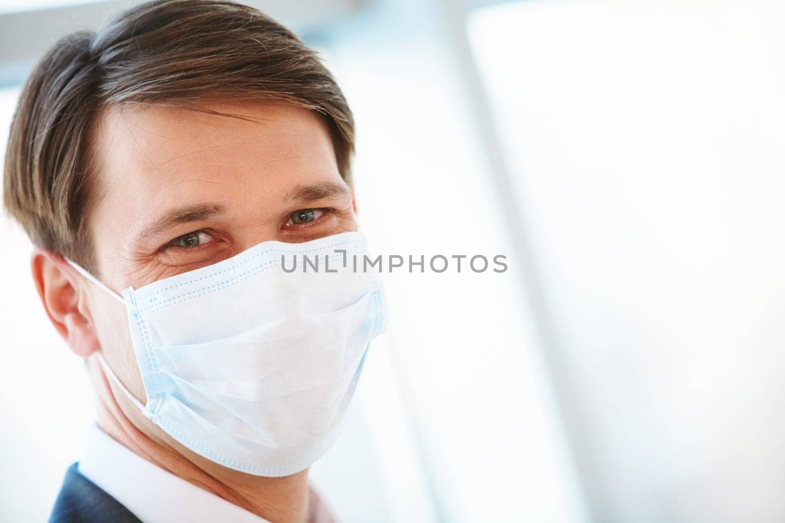 Portrait of businessman in protective mask looking at you