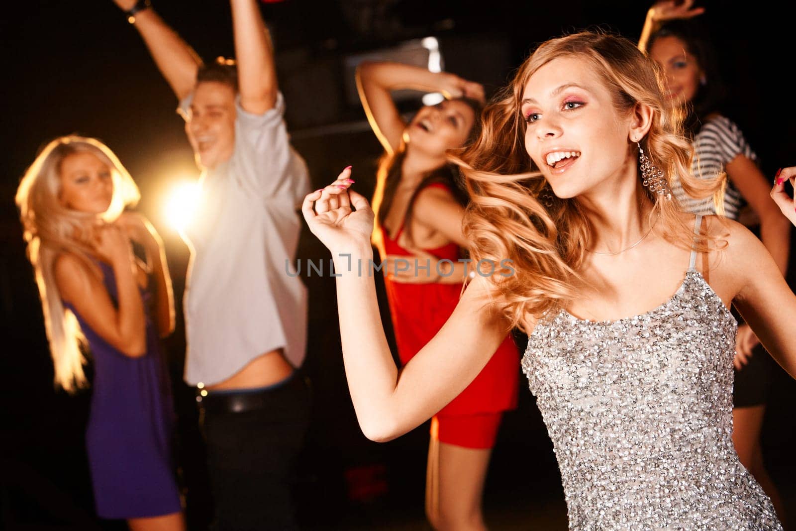 Portrait of energetic dancer on background of happy teens having fun