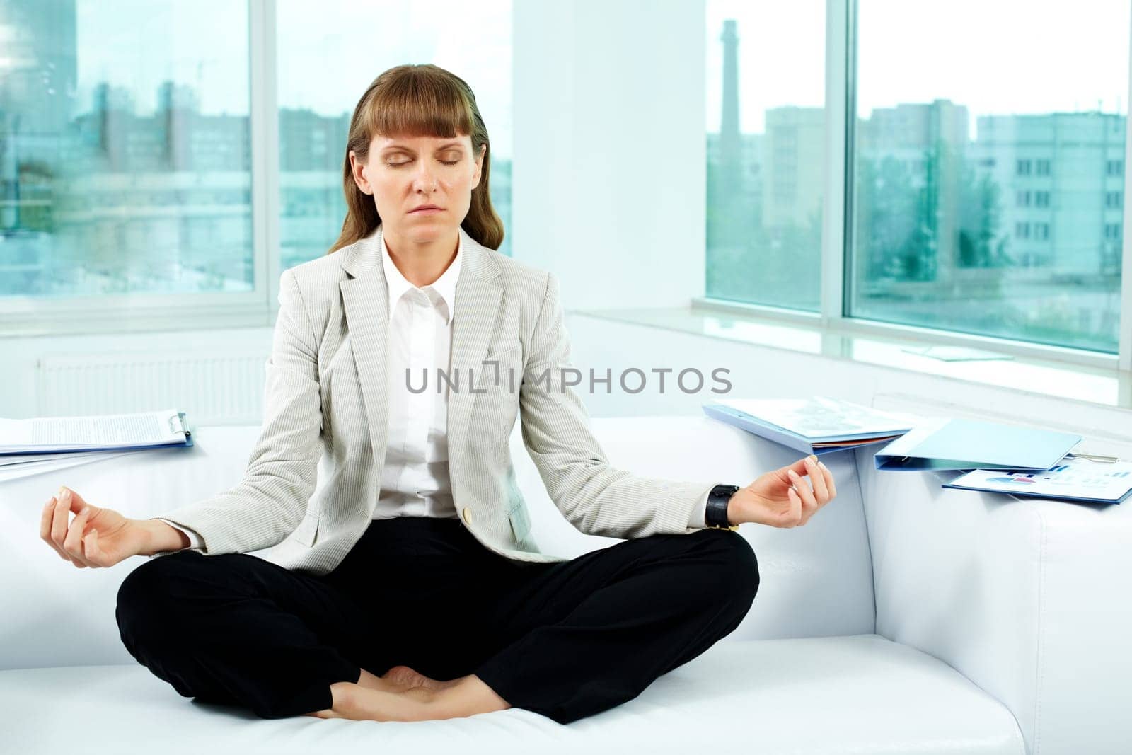 Portrait of attractive office worker meditating in office