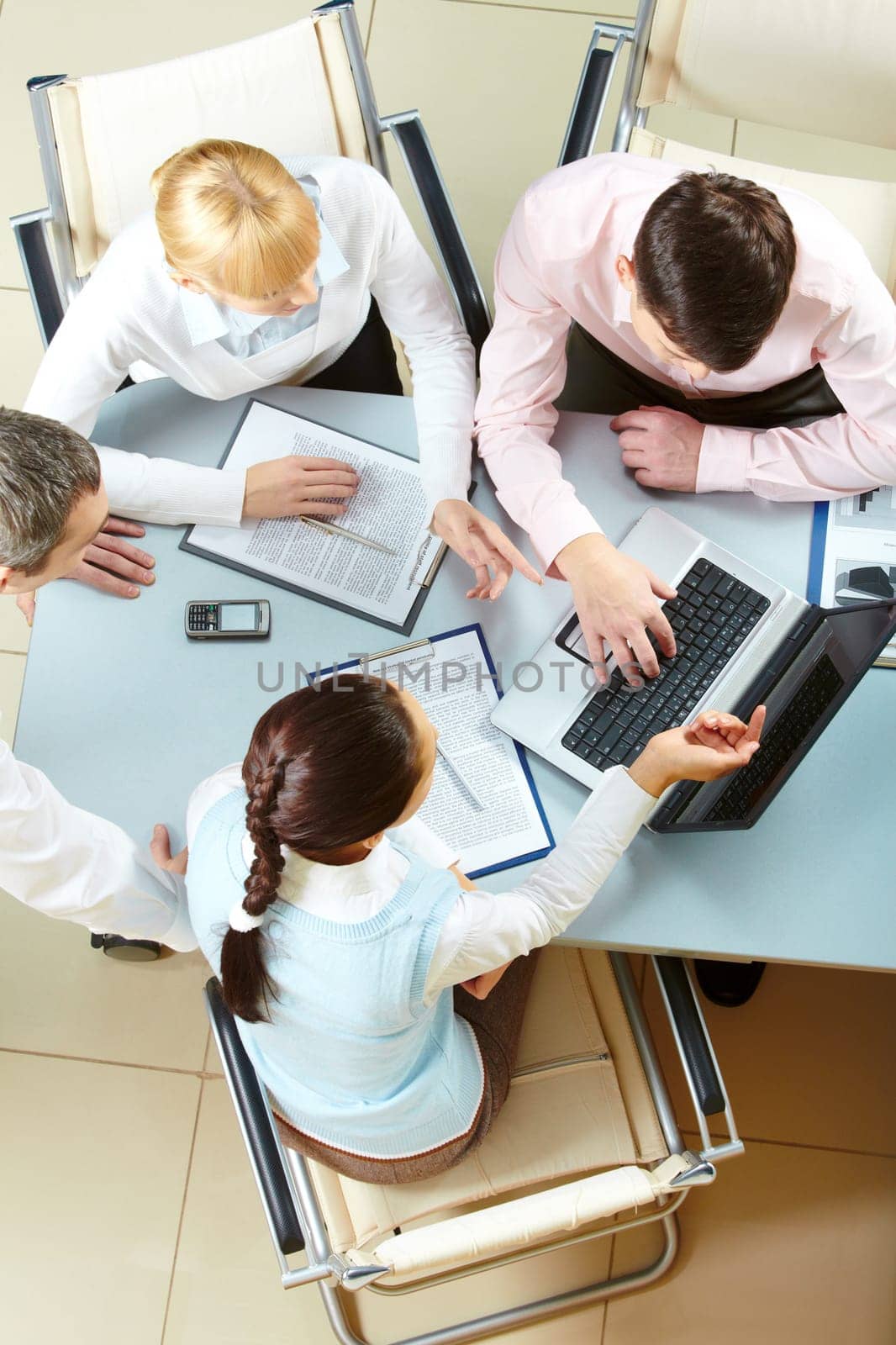 Four businesswomen communicating and looking at the laptop screen