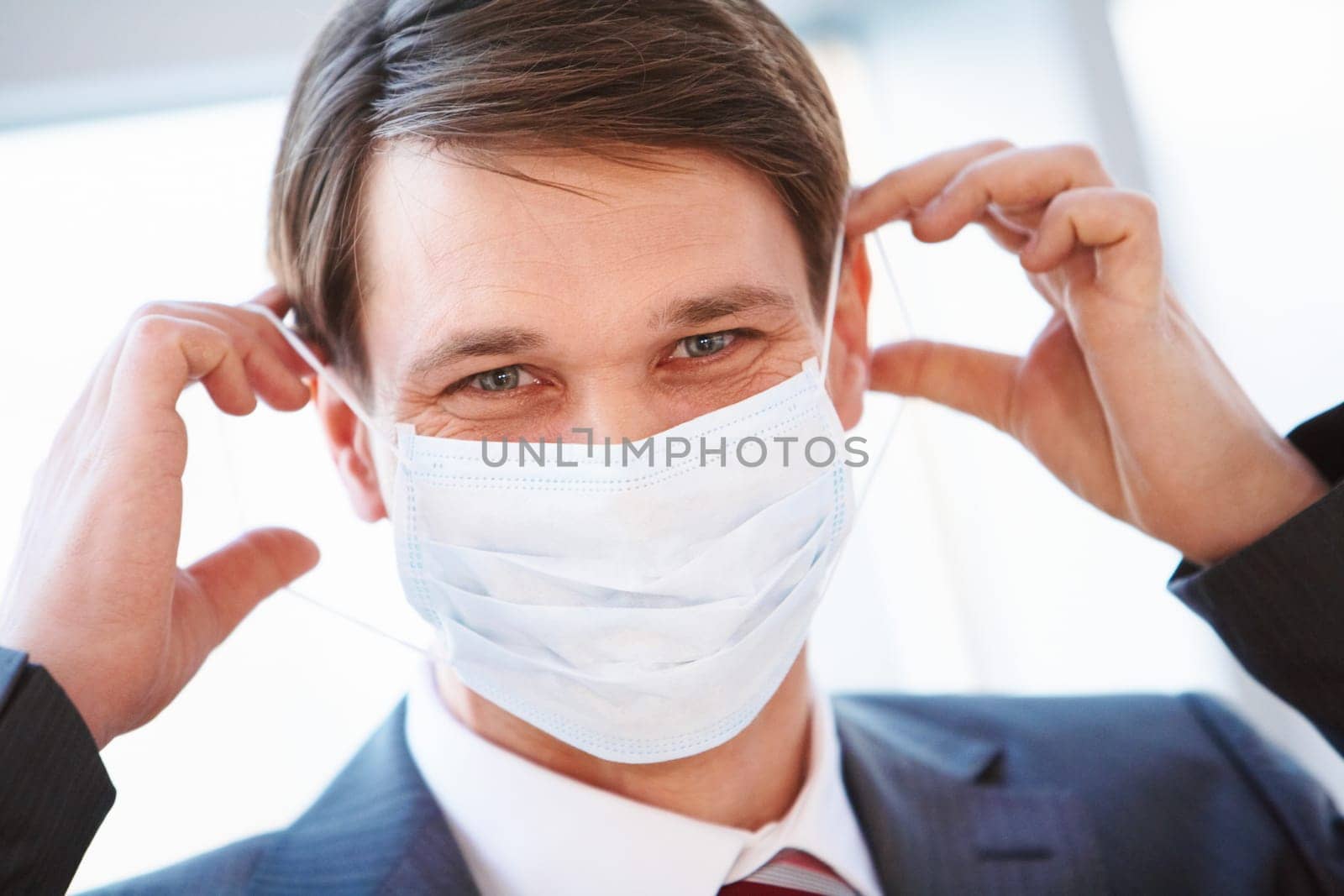 Portrait of businessman with protective mask going to put it on