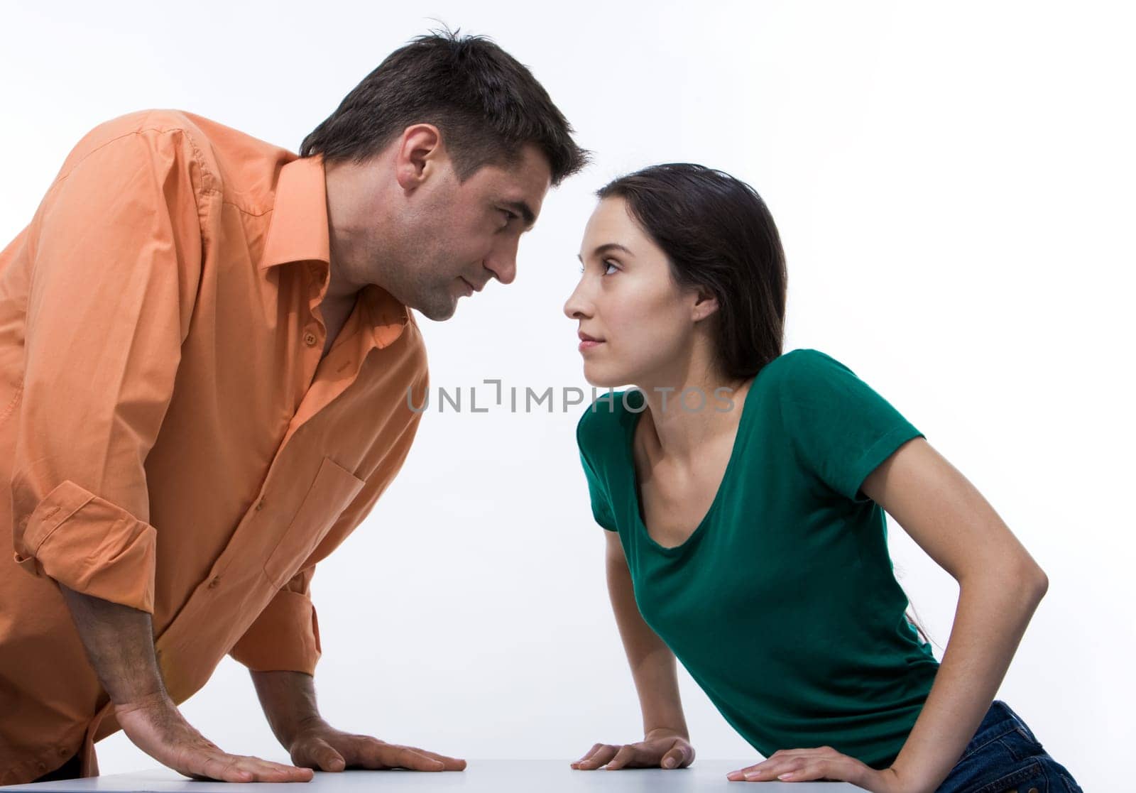 Man and woman looking at each other with displeasure on white background