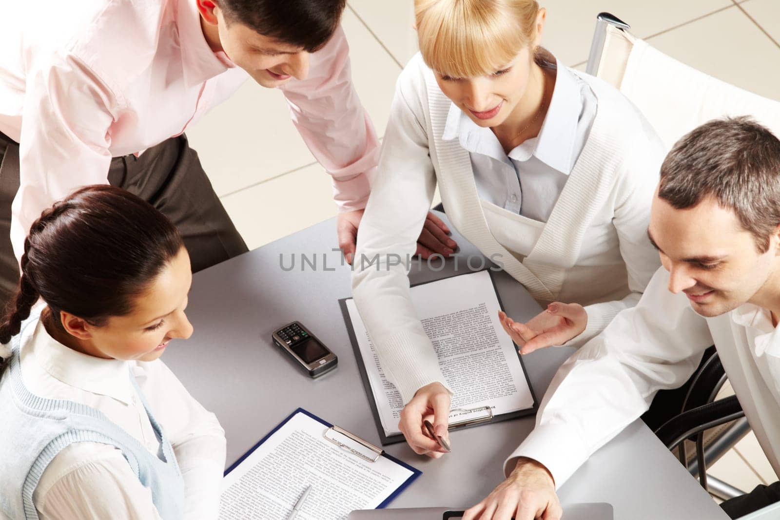 Above view of friendly workteam discussing business papers
