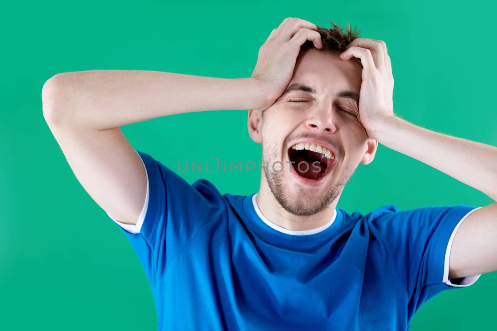 Portrait of young man full of joy over green background