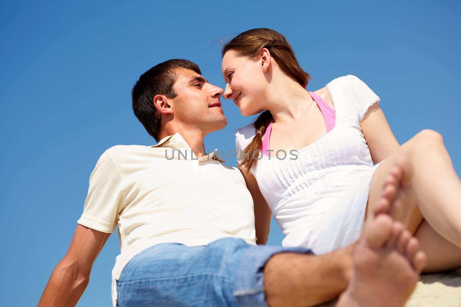 Photo of peaceful couple looking at each other with blue sky on background