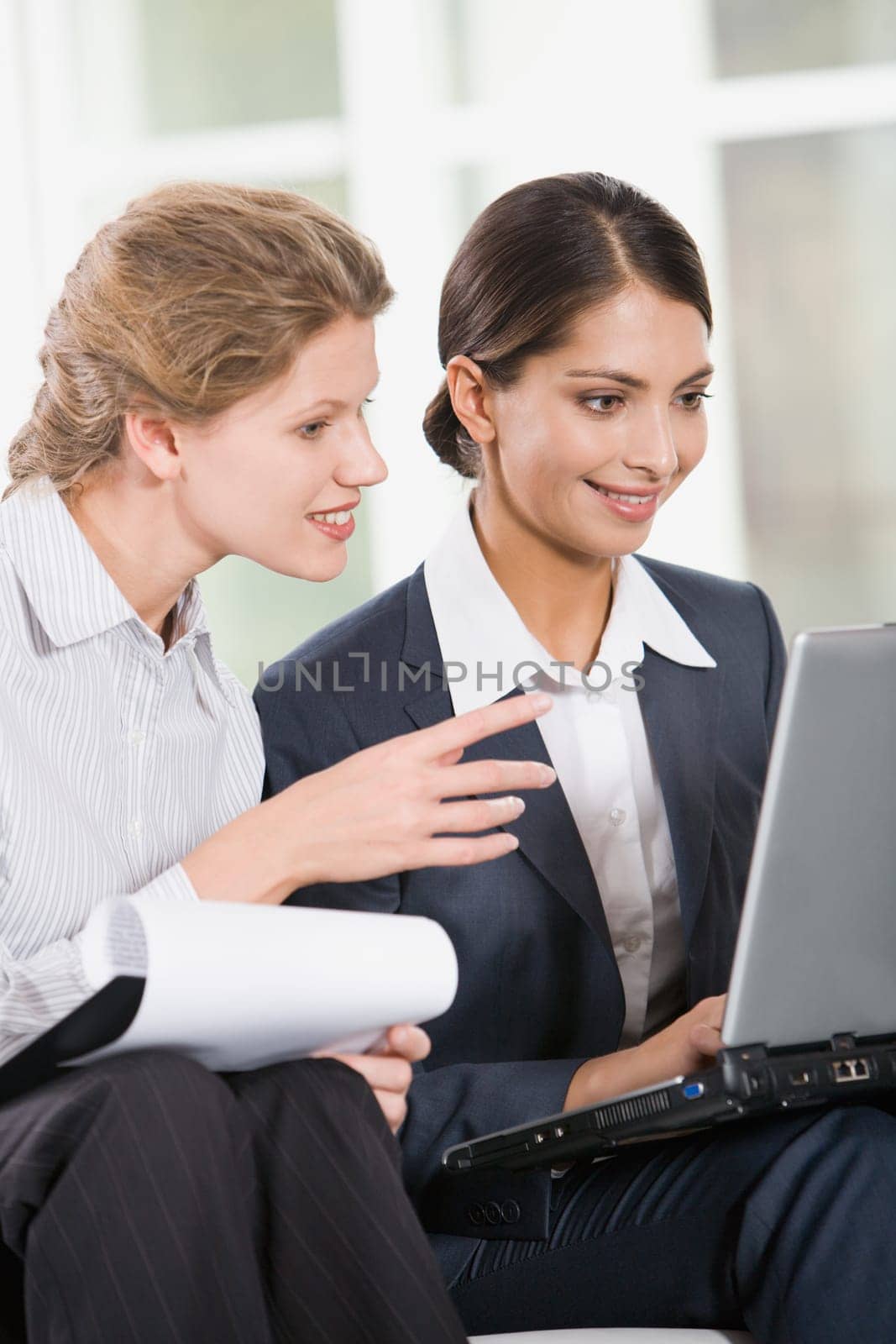 Portrait of two business women looking at the monitor of laptop