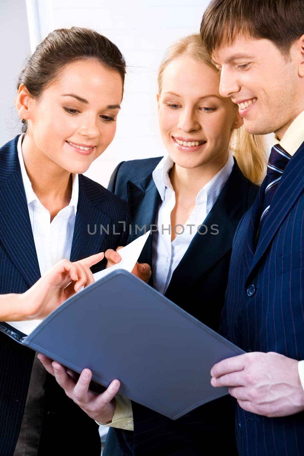 Team of three people discussing an important document at business meeting