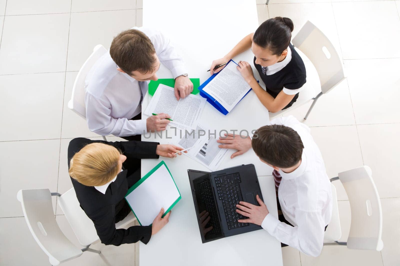 Above view of friendly workteam discussing business plan at meeting