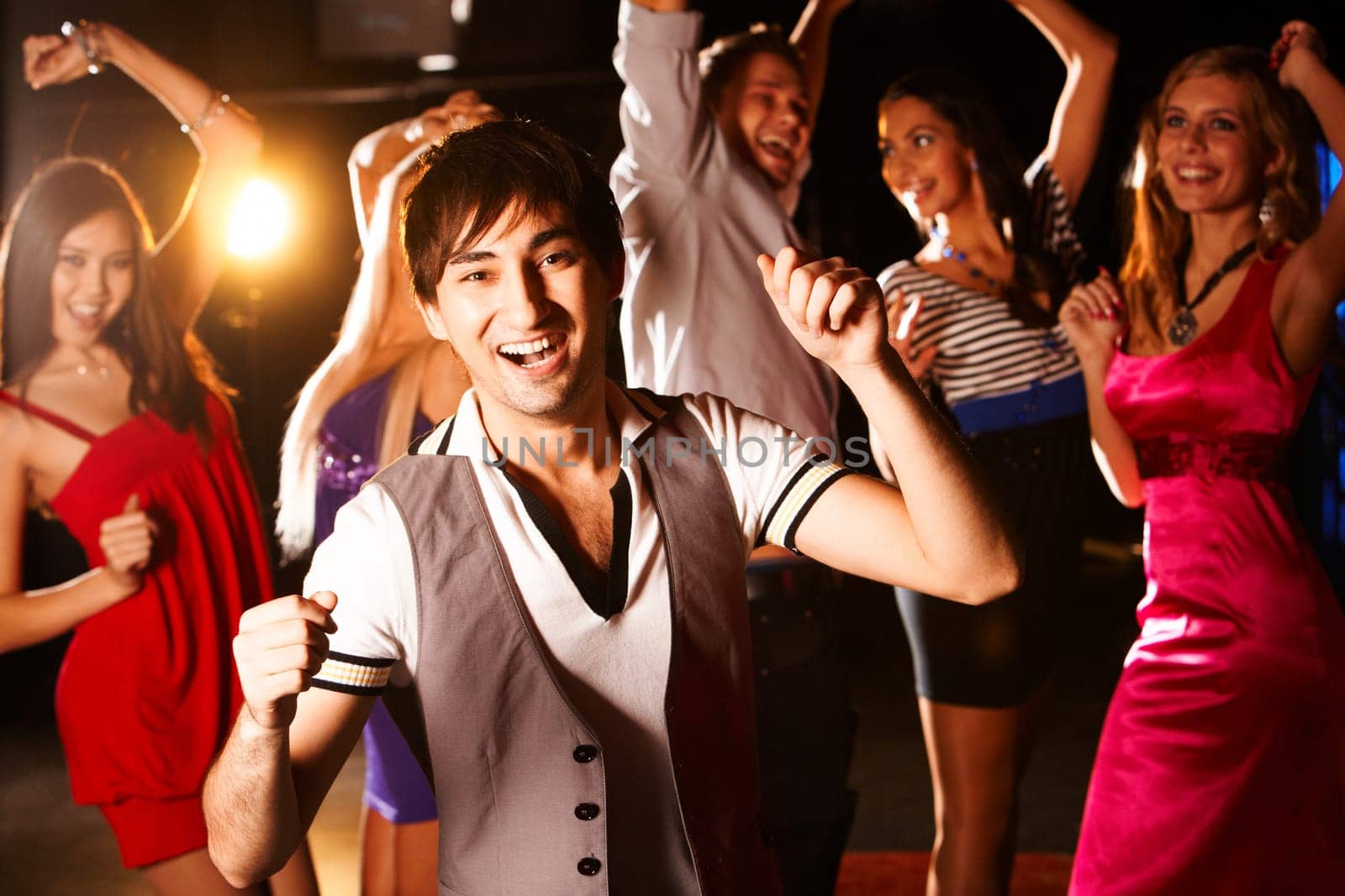 Portrait of energetic dancer on background of happy friends having fun