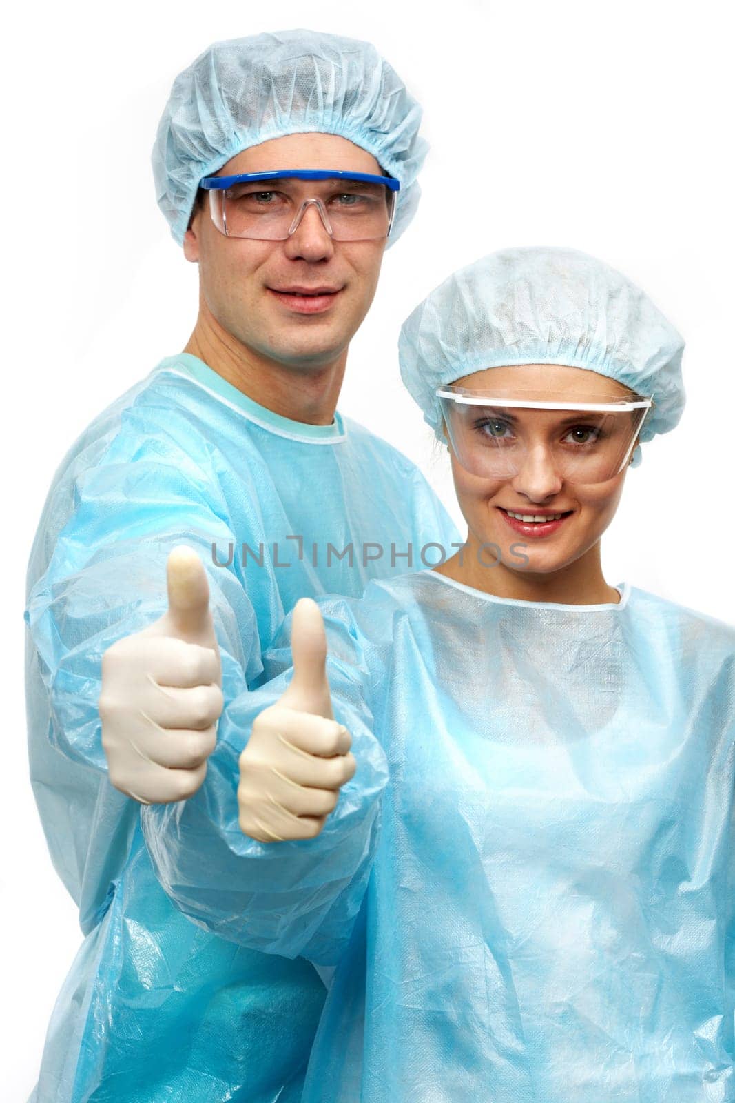 Two surgeons showing thumbs and smiling isolated on white