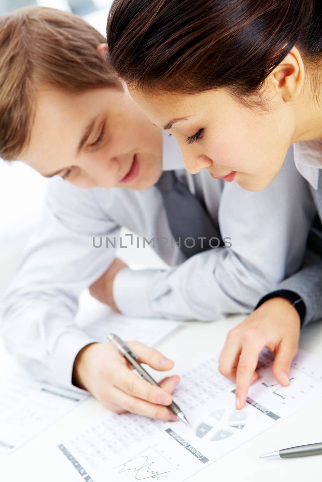 Successful businessman and his pretty colleague discussing papers