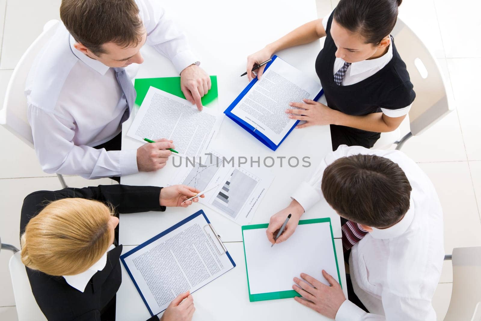 Above view of friendly workteam discussing business plan at meeting