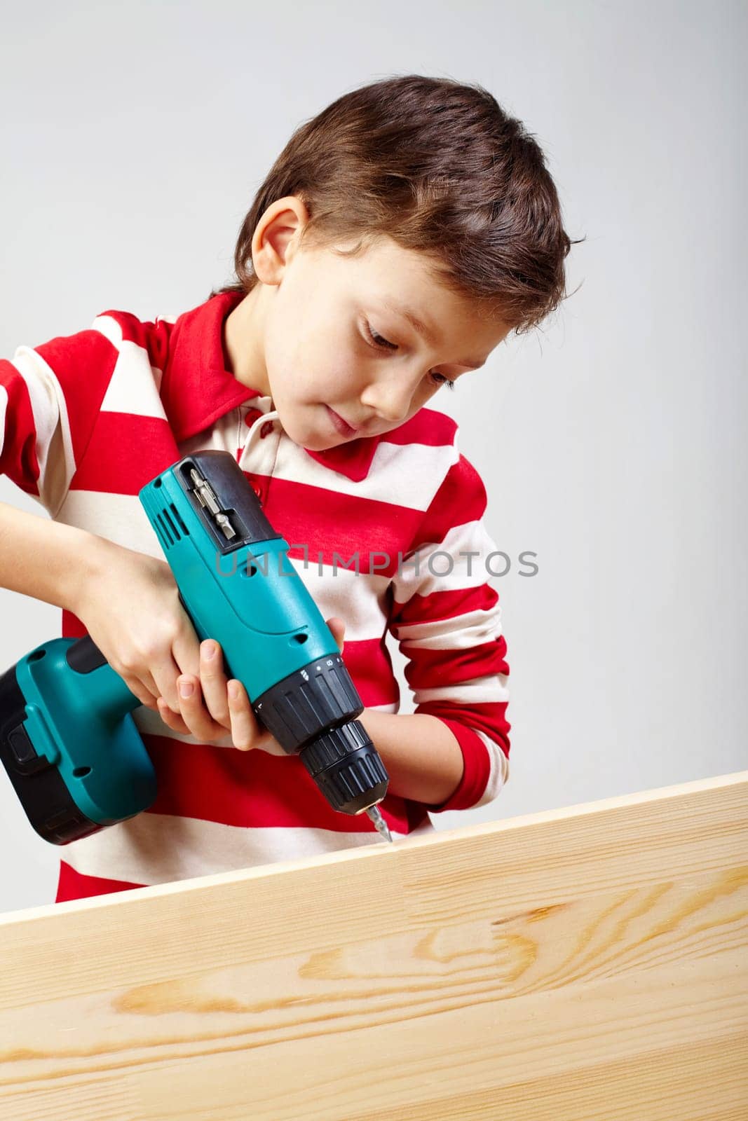 Portrait of drilling boy in workshop