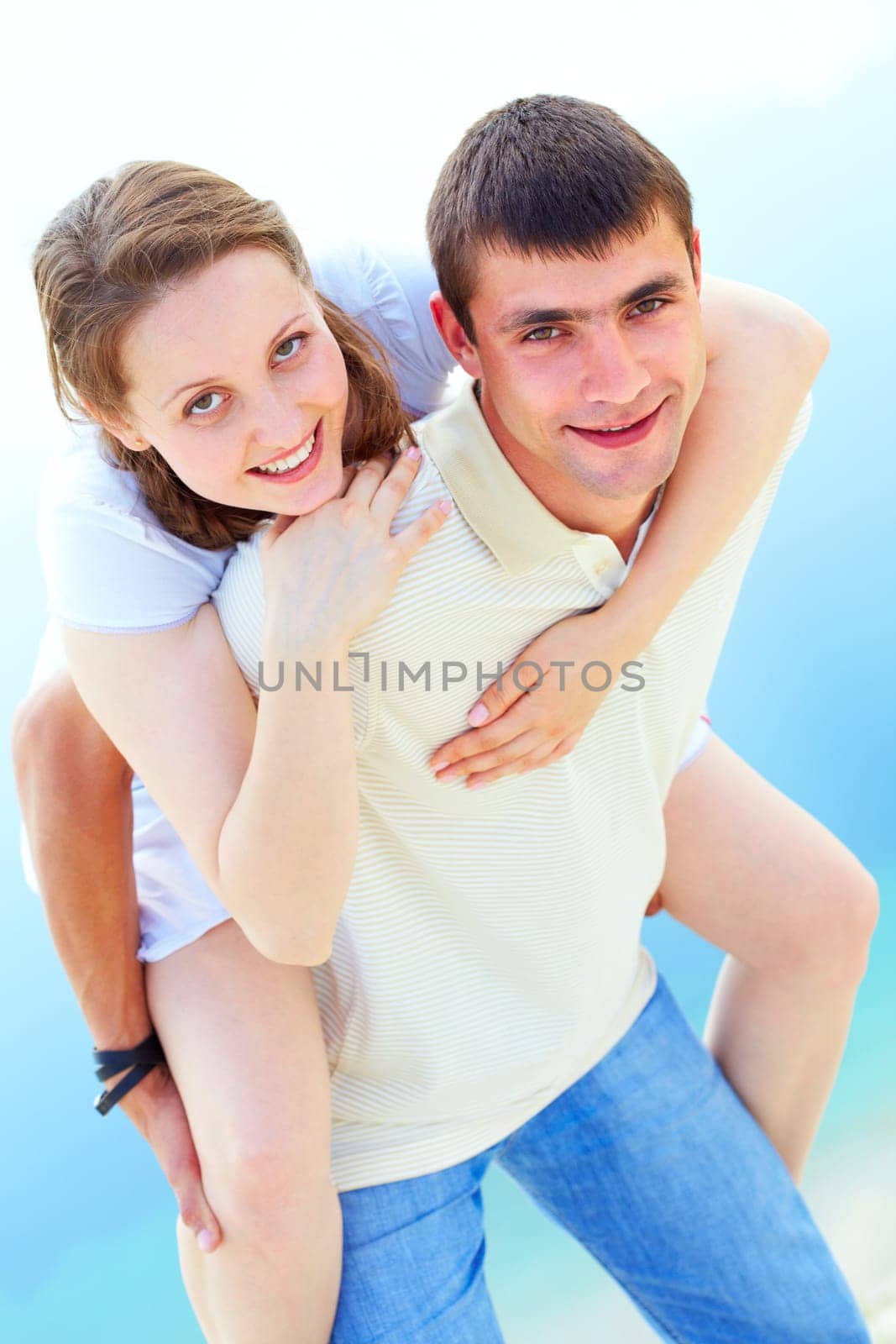 Photo of happy girl embracing her boyfriend and both looking at camera