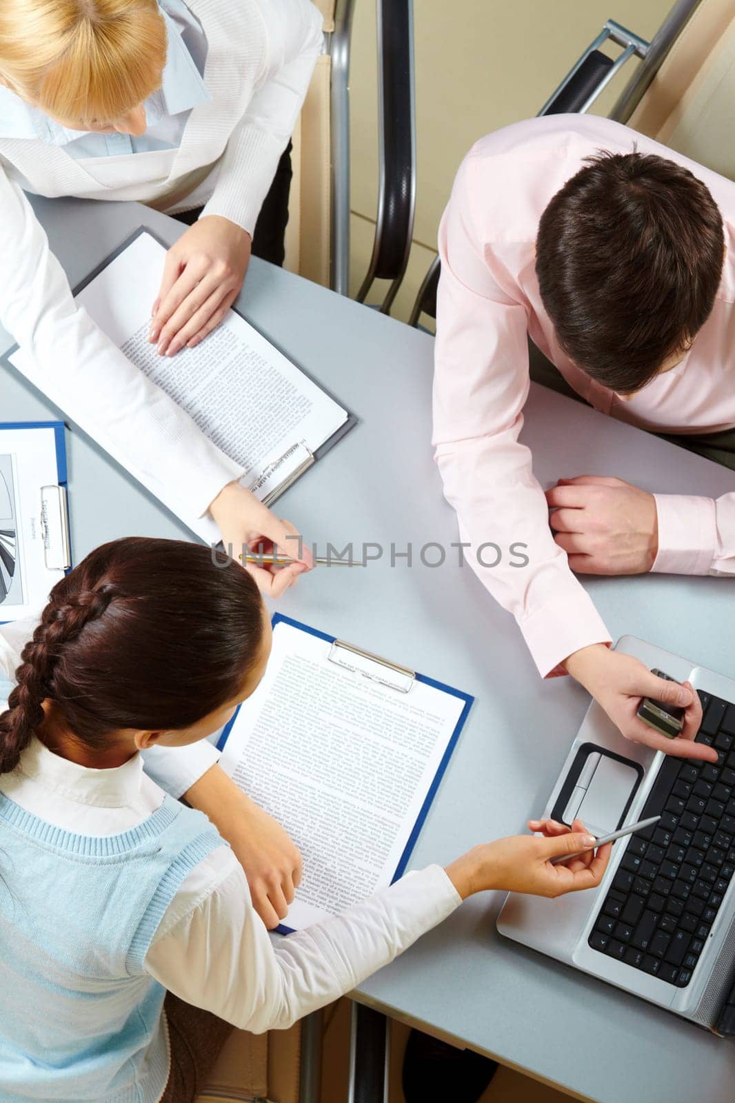 Above view of three business partners interacting at meeting