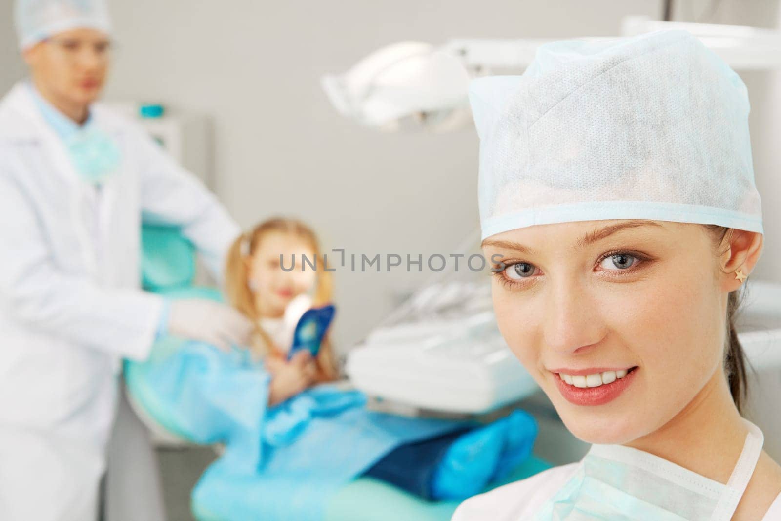 Portrait of a stomatologist against her colleague and a patient