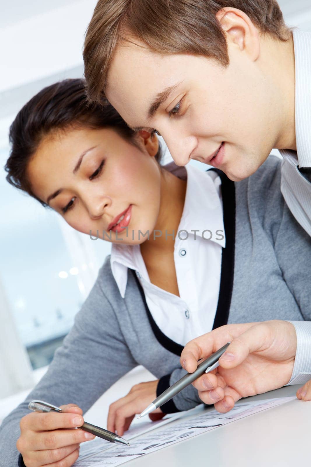 Successful businessman and his pretty colleague working with papers