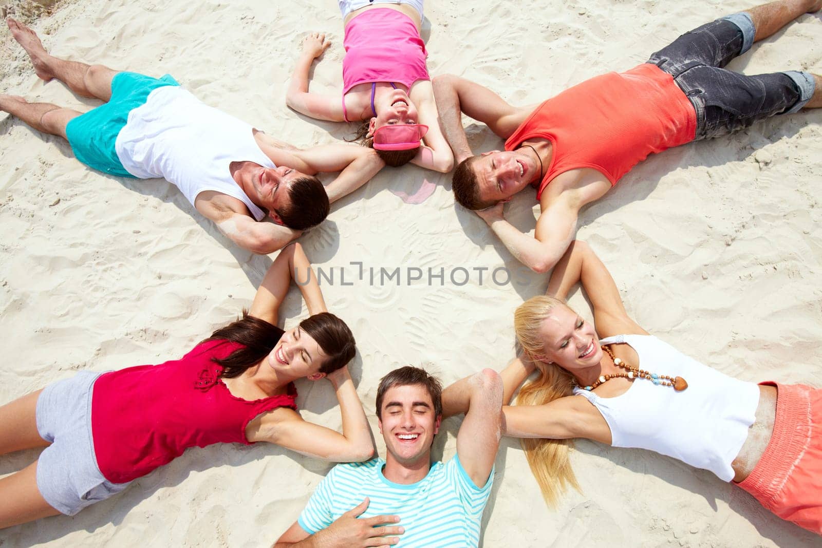 Six friends having rest on sandy beach