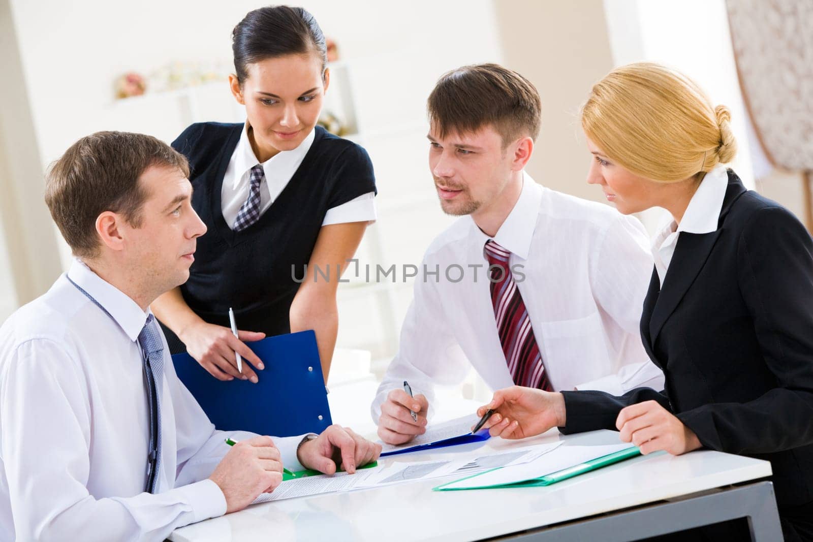 Serious business partners looking at their boss explaining new plan
