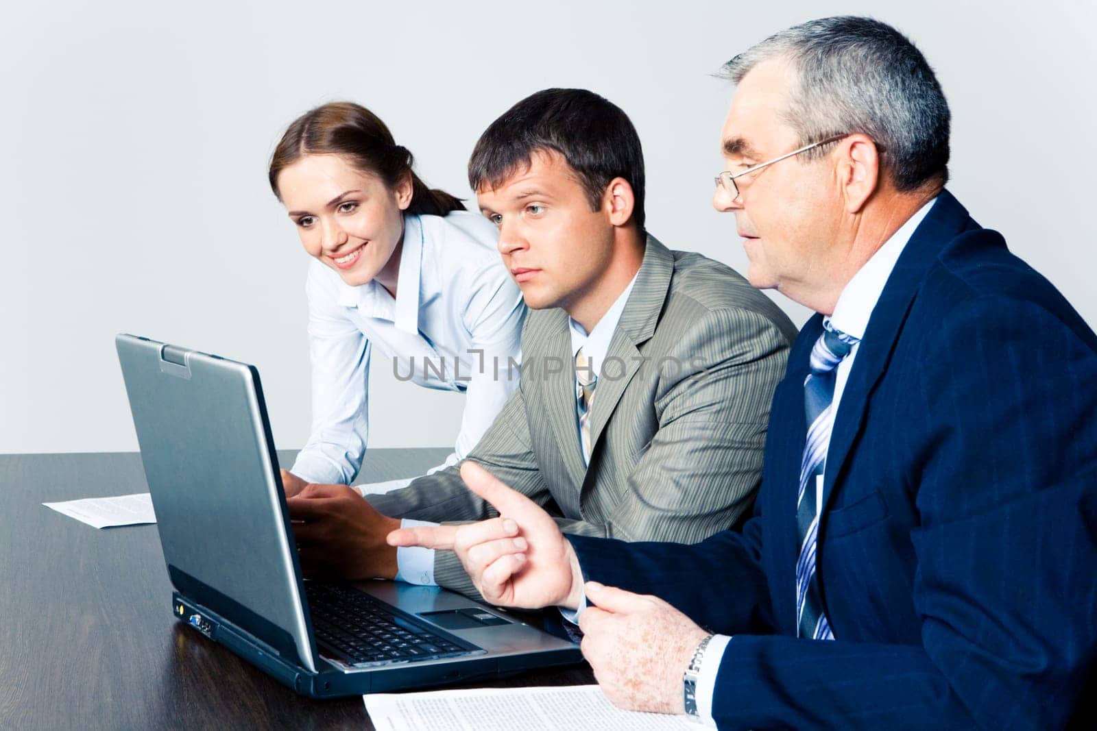 Image of confident boss explaining some computer work to coworkers