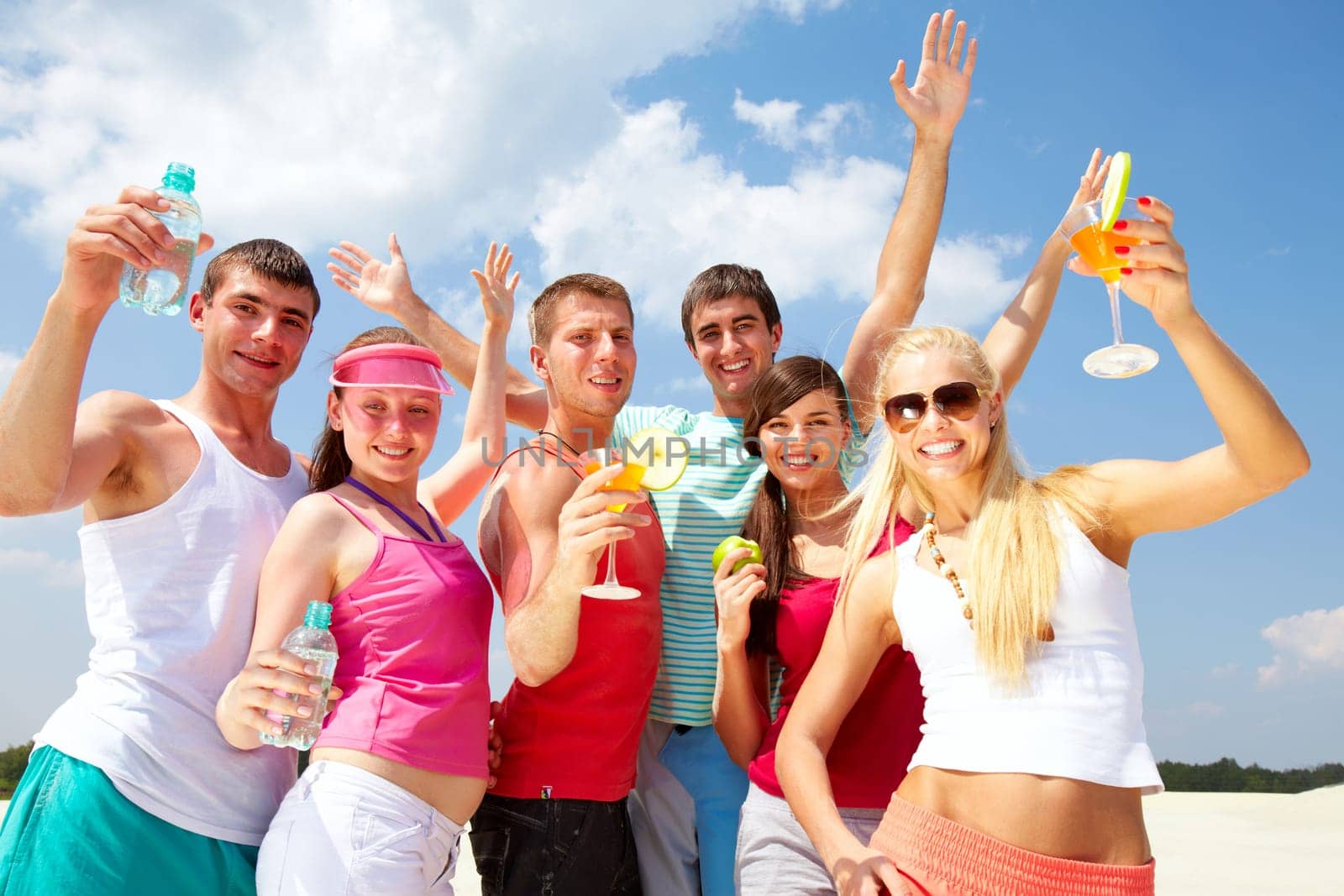Six friends dancing on beach with cocktails