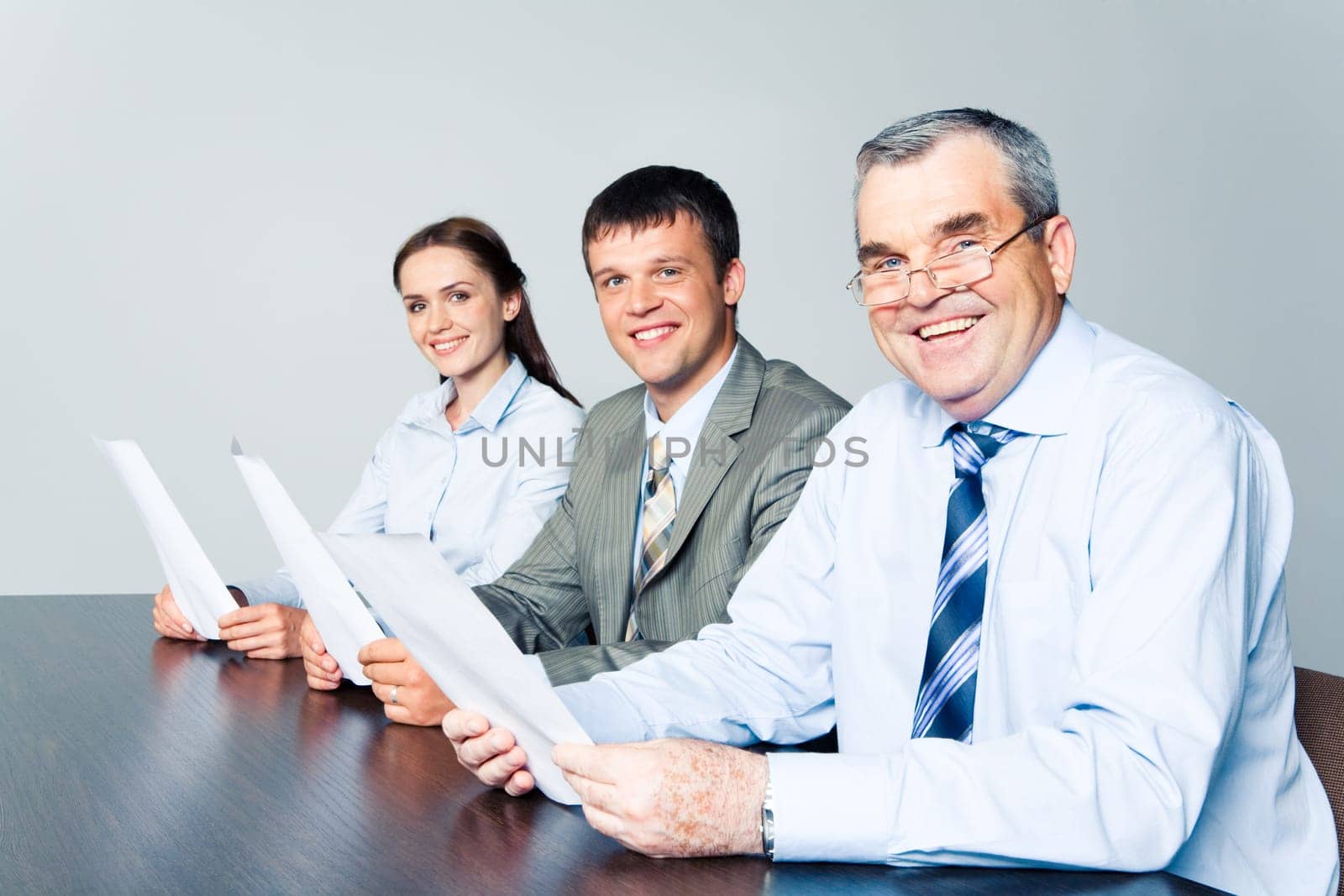 Group of successful business people sitting at the table with senior leader in front