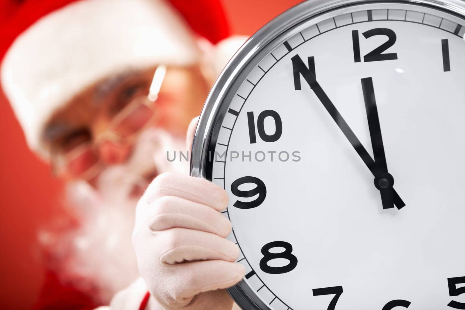 Photo of clock showing five minutes to midnight with Santa on background