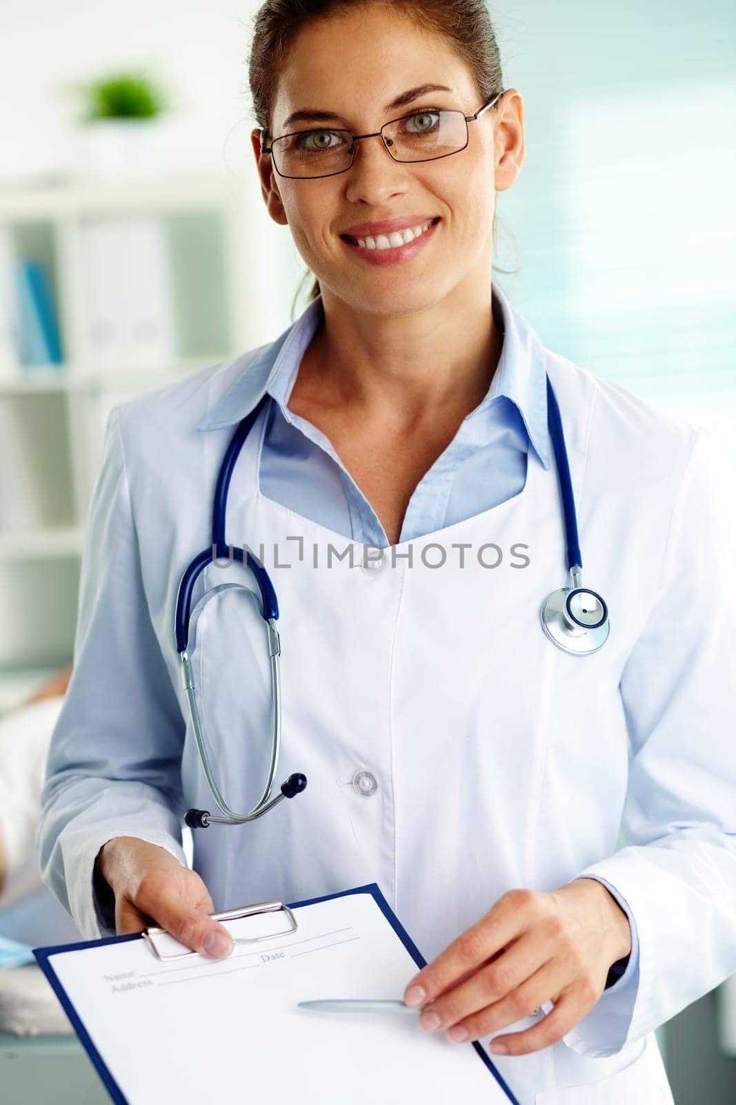 Portrait of confident female doctor with clipboard looking at camera