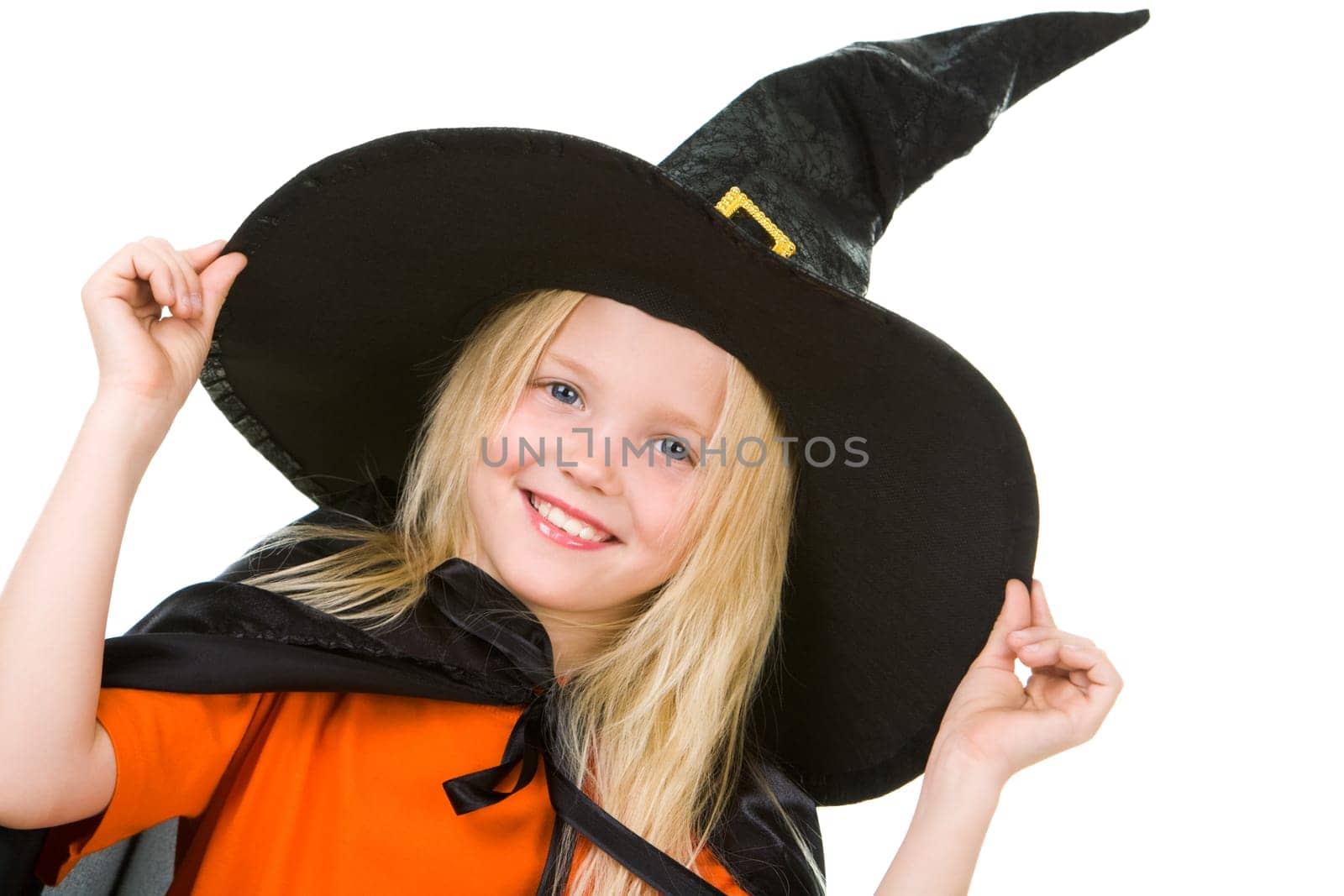 Portrait of girl in witch costume posing before camera