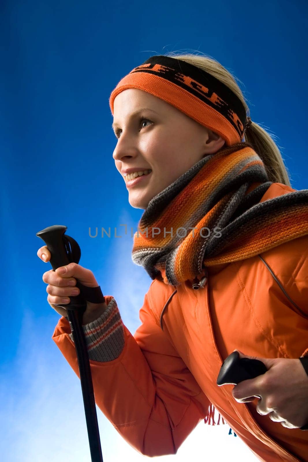 Portrait of a young skiing woman in the orange sports wear