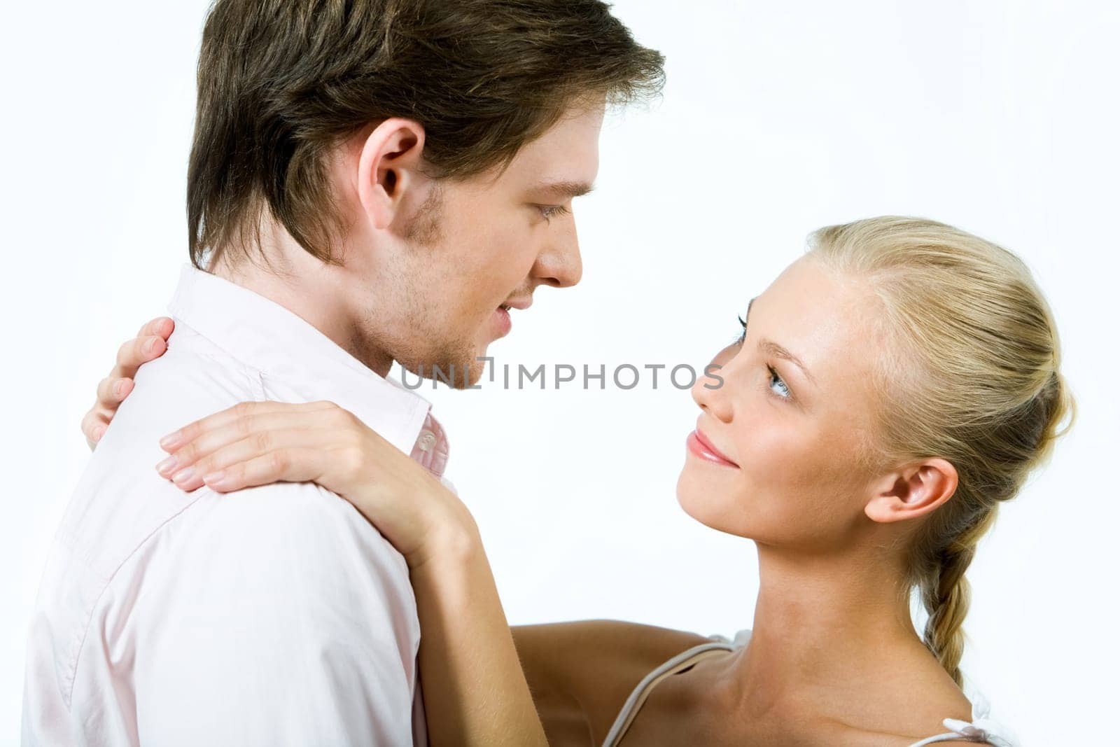 Handsome guy looking at pretty blonde who keeping her hands on his shoulders