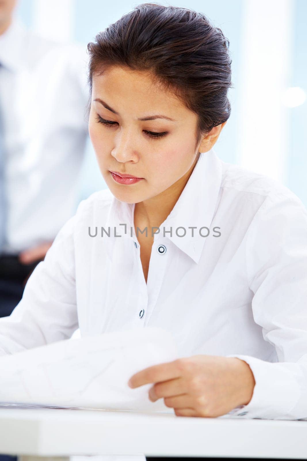 Portrait of serious businesswoman reading document in office
