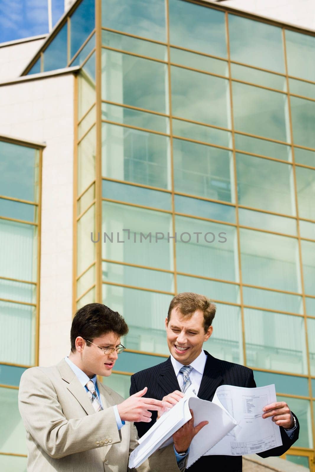 Businessman  is showing  a new  project to his boss on the  background of building