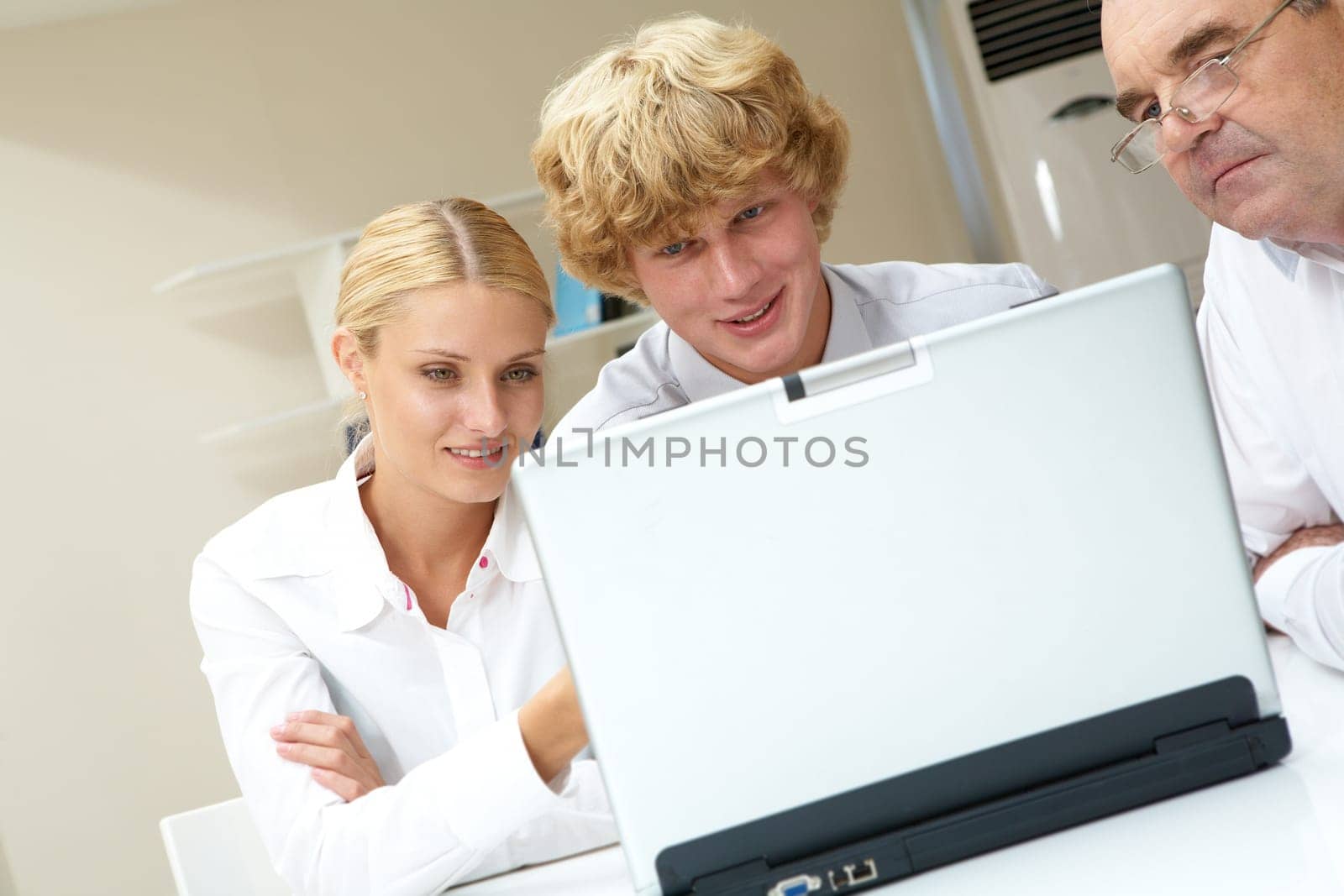 Portrait of workteam discussing computer project at meeting