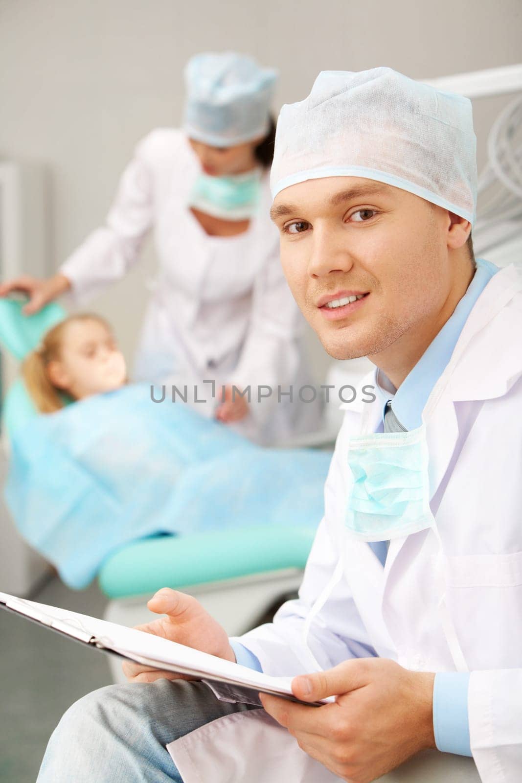 Portrait of a stomatologist against a nurse and a patient