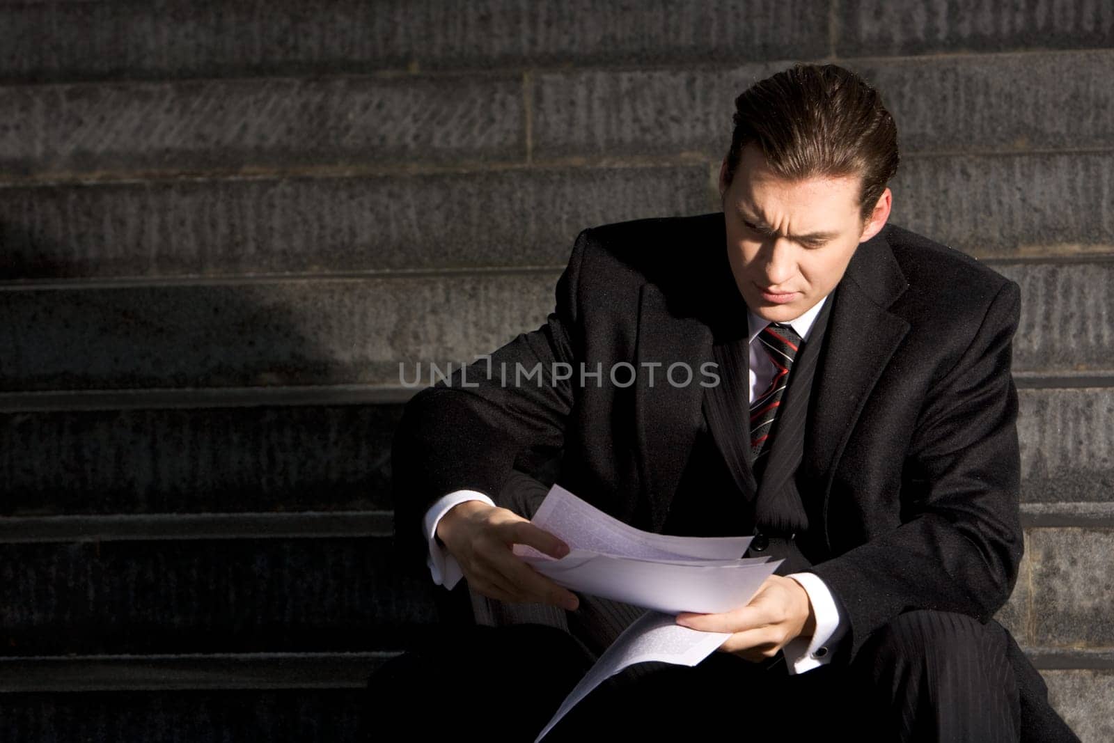 Portrait of unhappy businessman reading the document