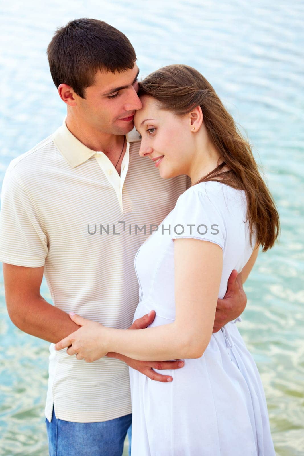 Photo of peaceful couple enjoying being together with blue water on background