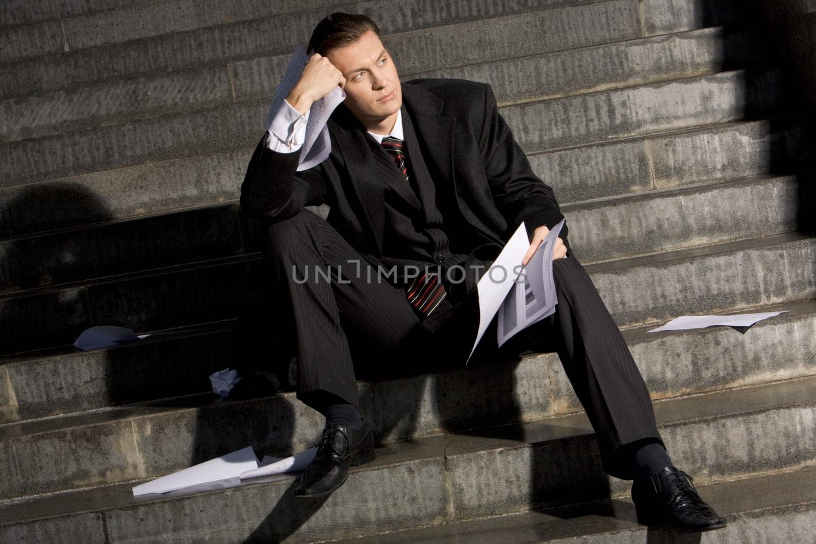 Photo of young entrepreneur holding papers and looking aside