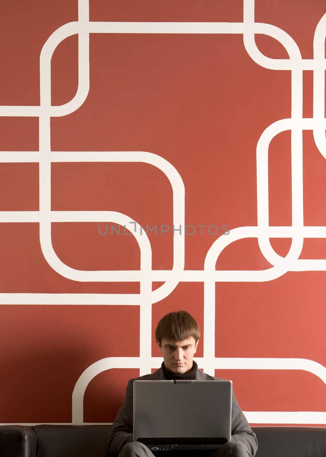 Portrait of serious businessman with laptop working in office