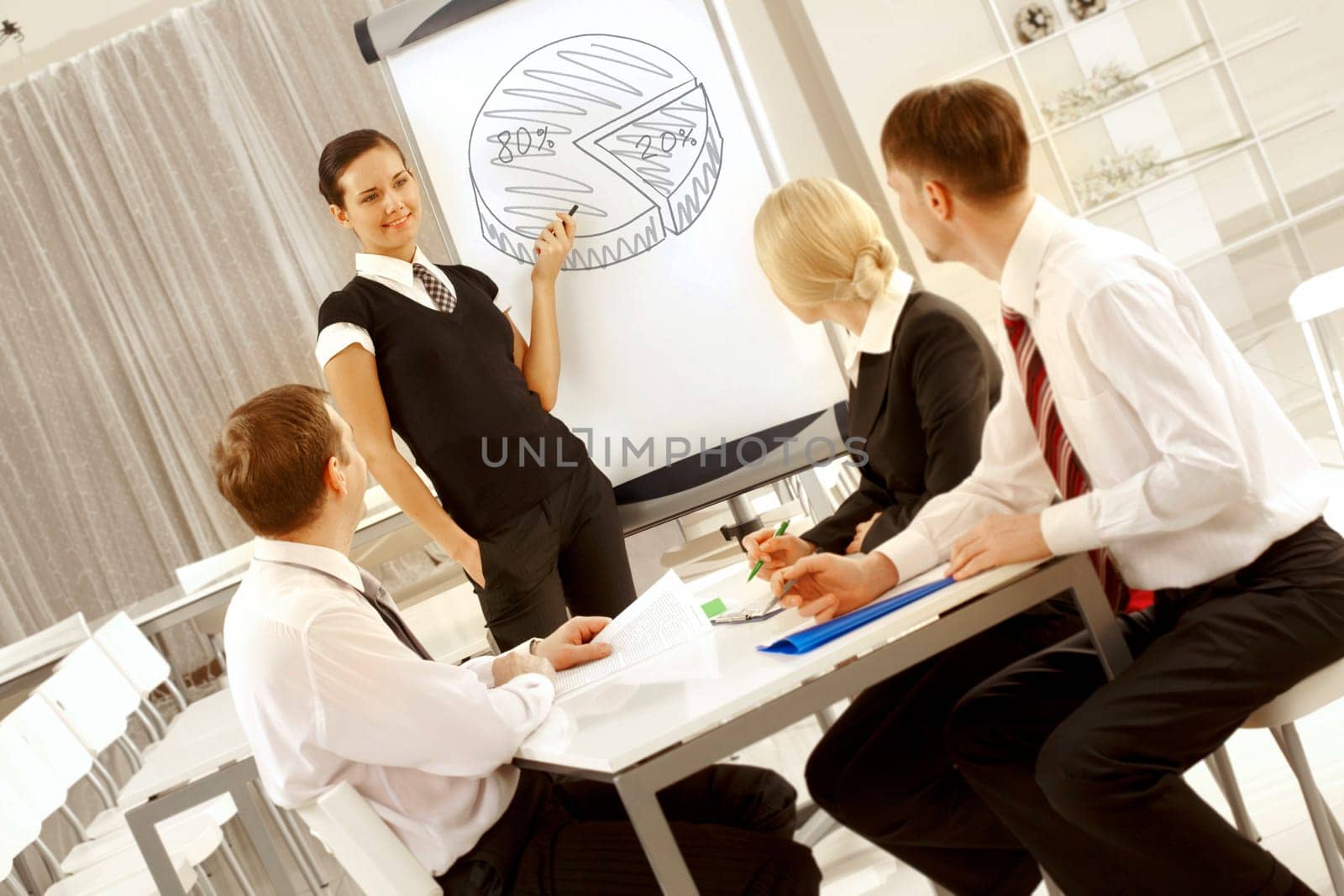 Photo of successful female standing by whiteboard and pointing at diagram on it at seminar