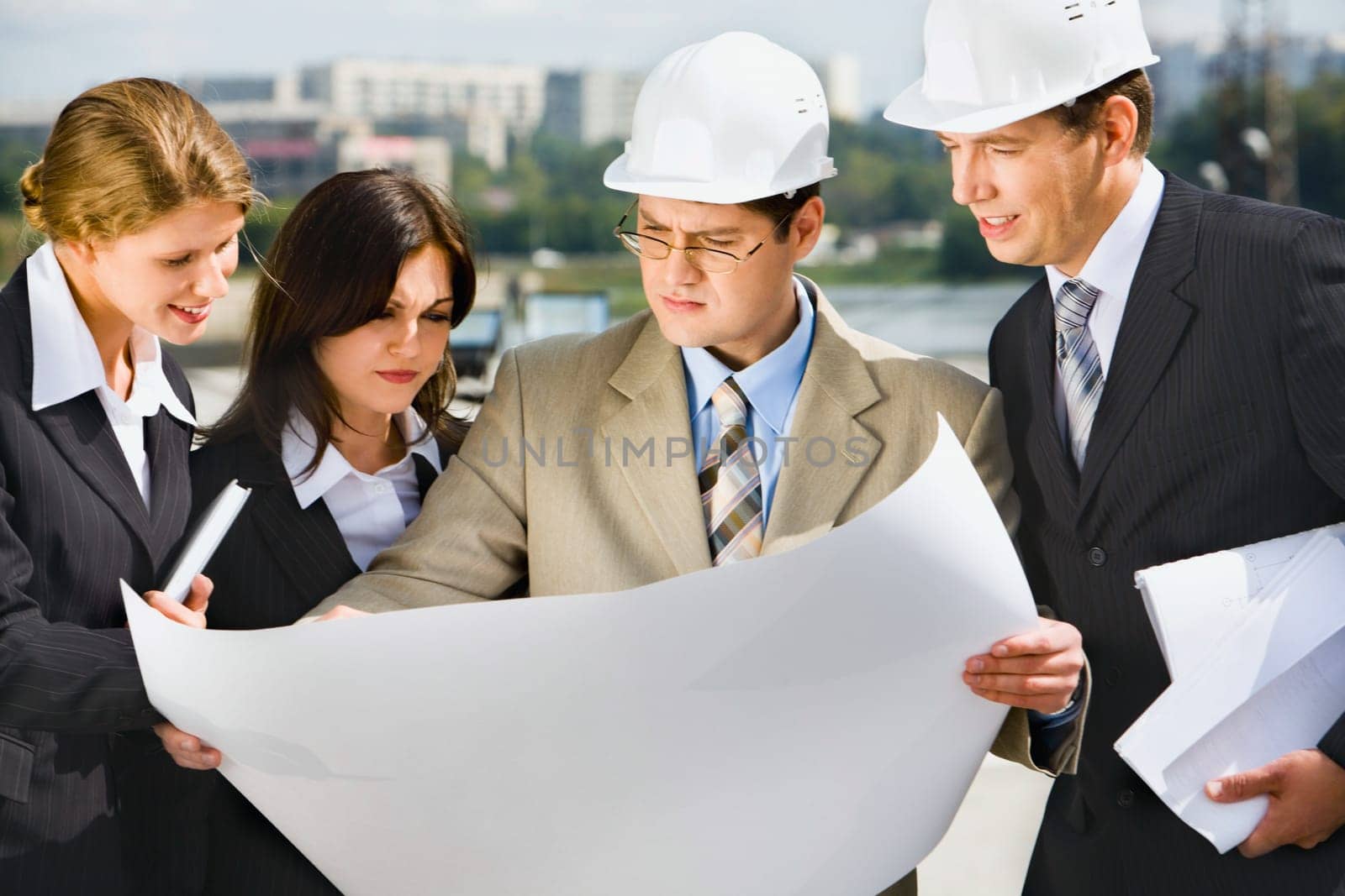 Architect is holding his project of building and showing it to customers