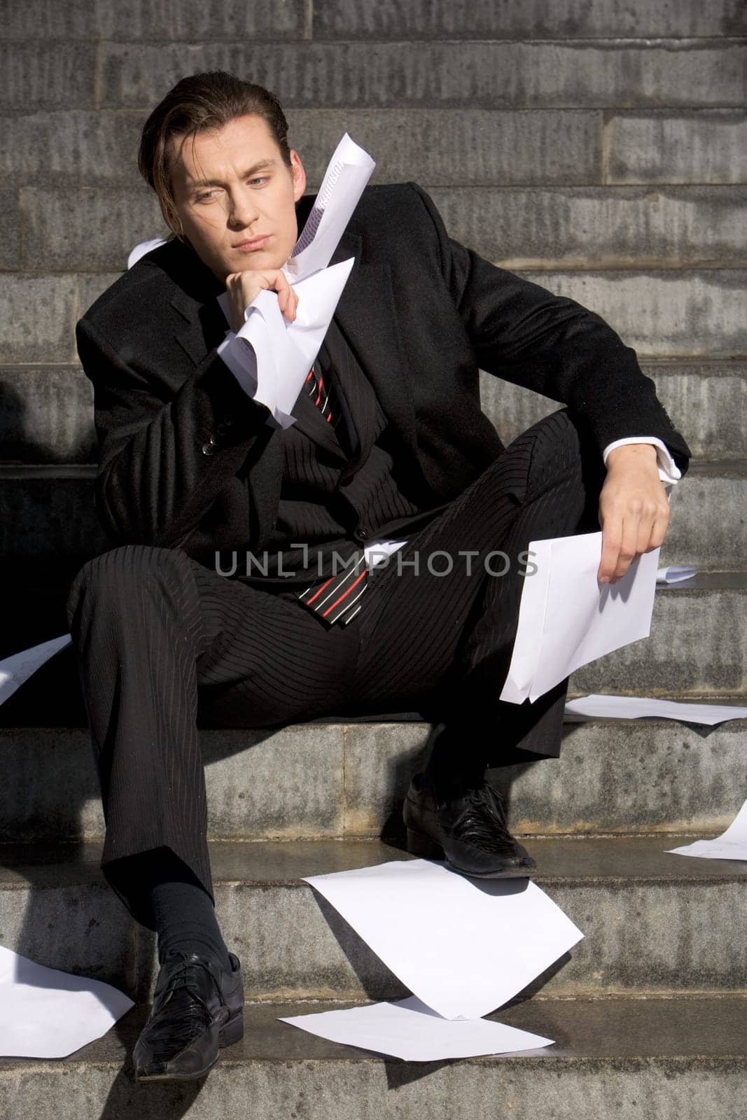Portrait of stressed specialist thinking about crisis while sitting on staircase