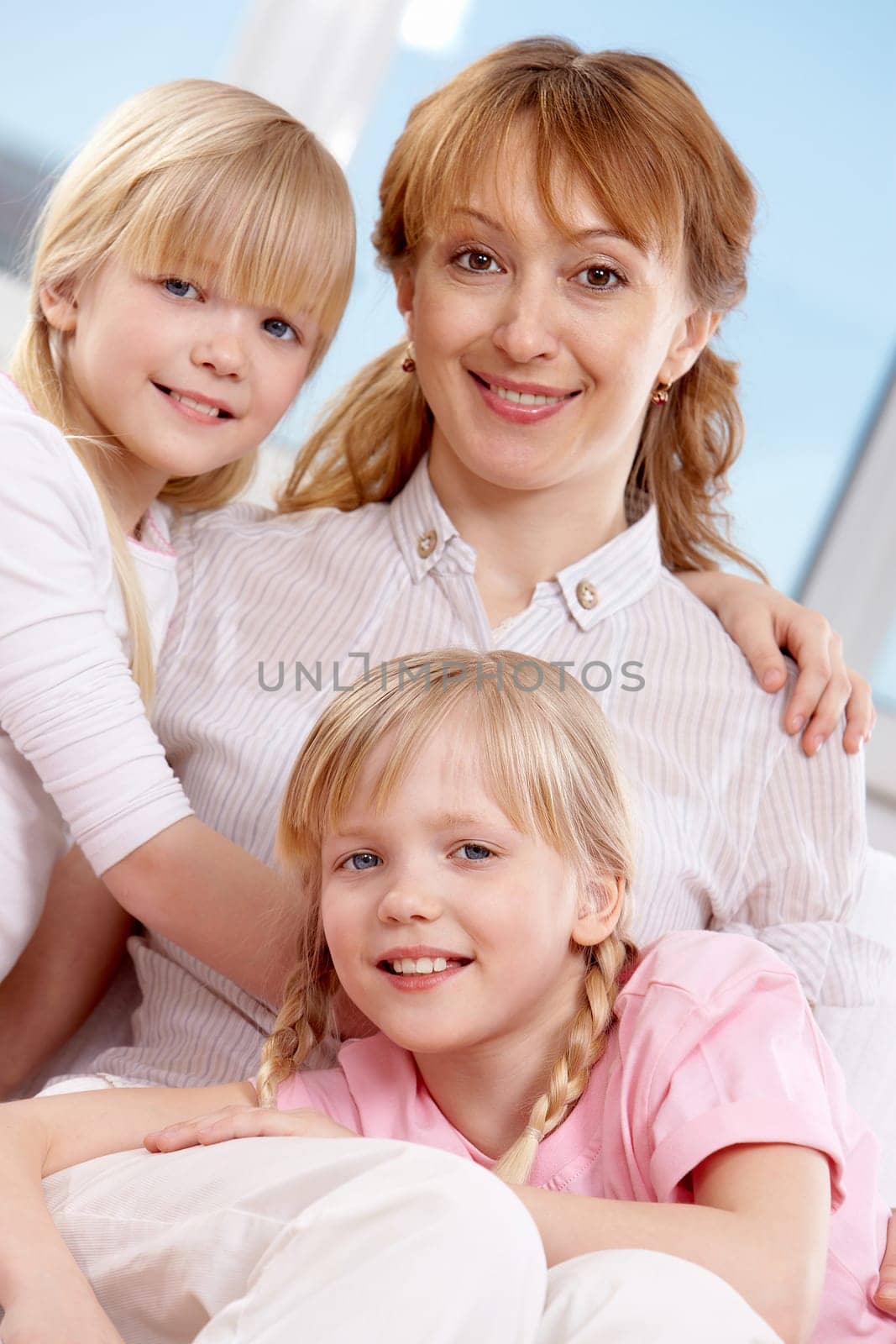Family of woman and twin sisters looking at camera