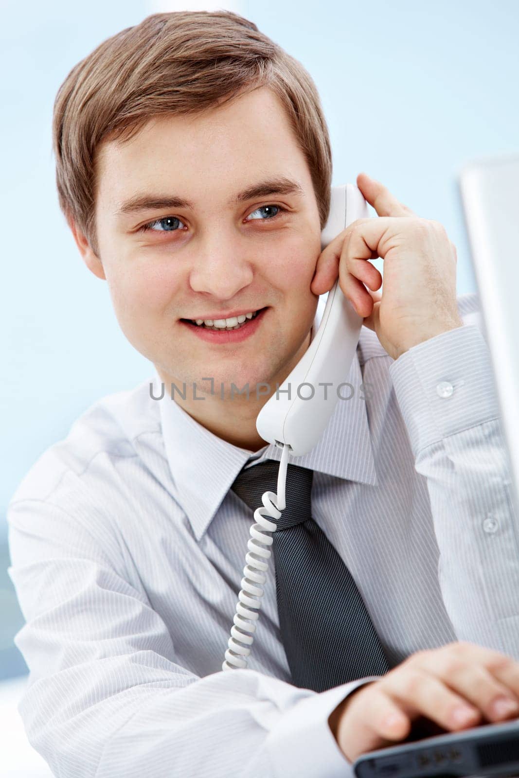 Portrait of smiling agent speaking by telephone